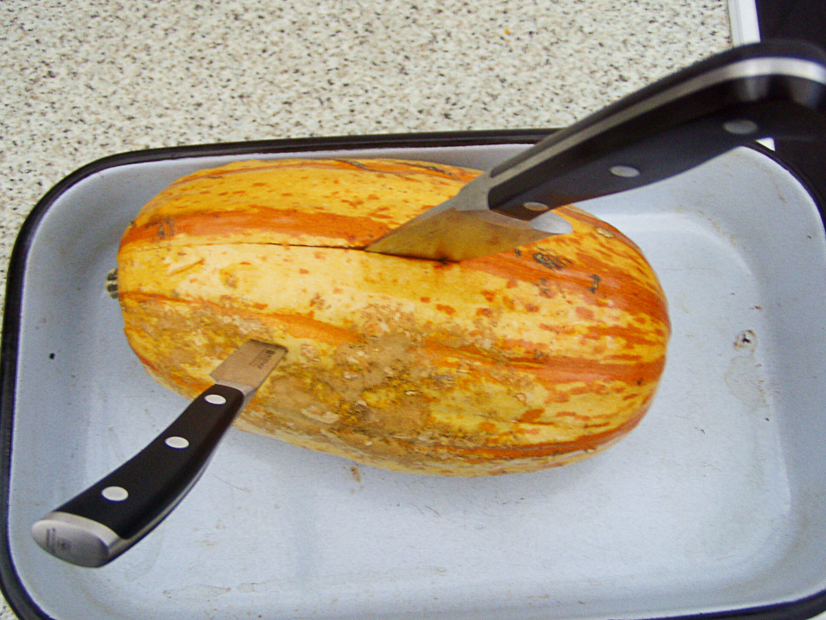 gegarter Spaghettikürbis, in dem ein kleines Messer vorn als Haltegriff und ein großes Messer stecken