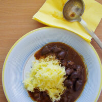 Spaghettikürbis mit Hähnchenherzen-Gulasch Spaghettikürbis als falsche Nudeln mit Hähnchenherzen-Gulasch auf blau gelb umrandeten Teller