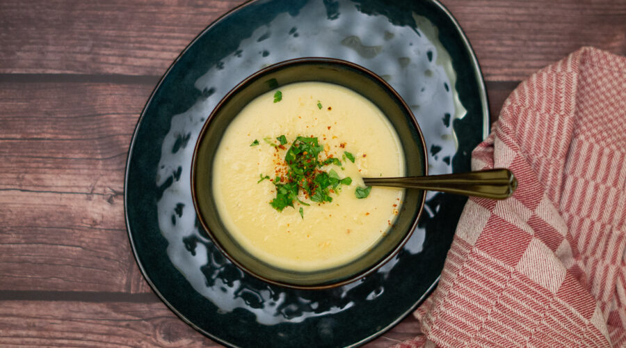 Steckrübensuppe mit Kokosmilch Schüssel mit gelber Steckrübensuppe und aufgestreutem Koriander